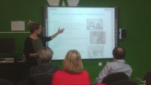 Imagen de la psicóloga Lucia Castroverde impartiendo la charla con el apoyo audiovisual de una presentación multimedia.